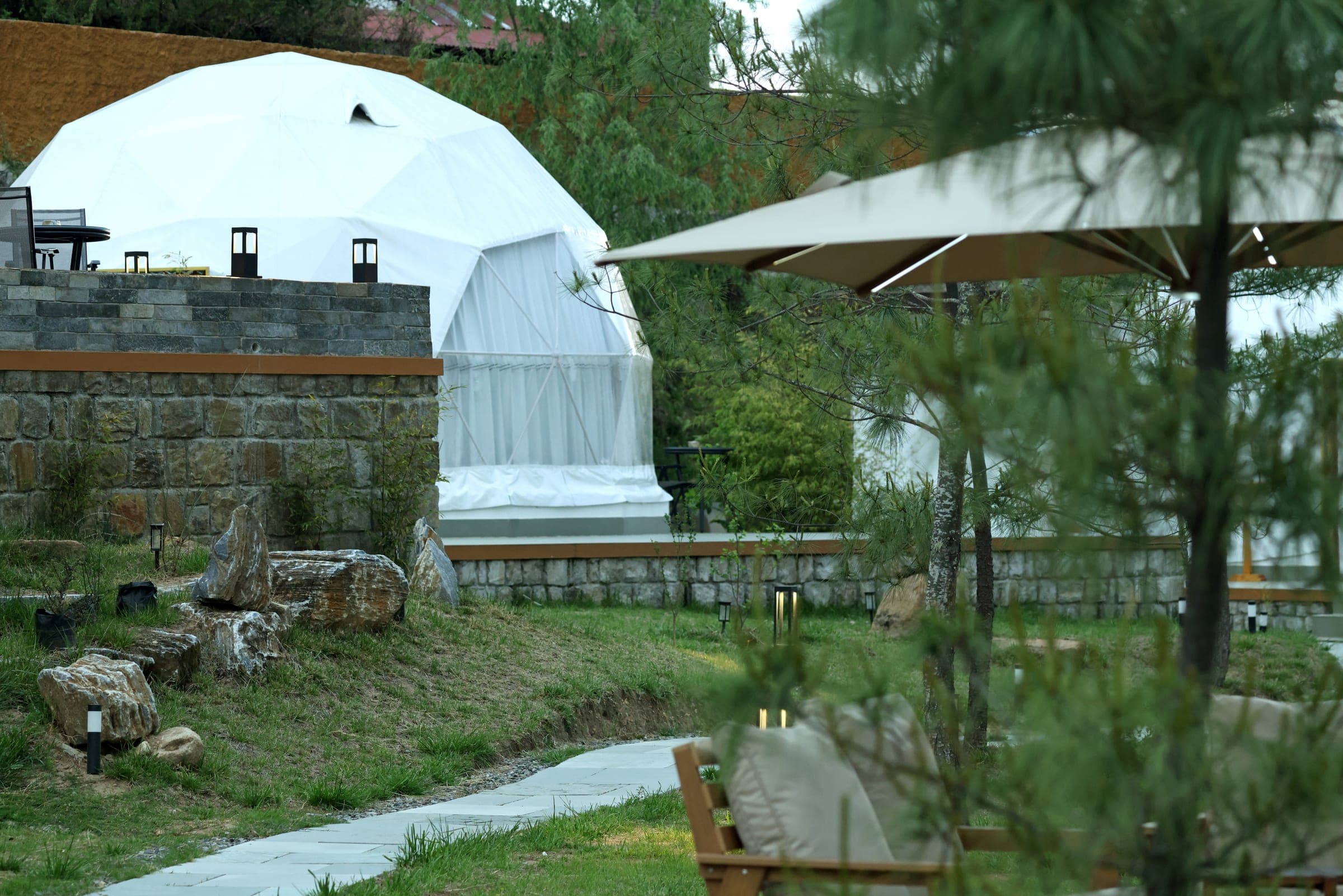 Private stone terrace outside a riverfront glamping dome at Highland Glamping Paro