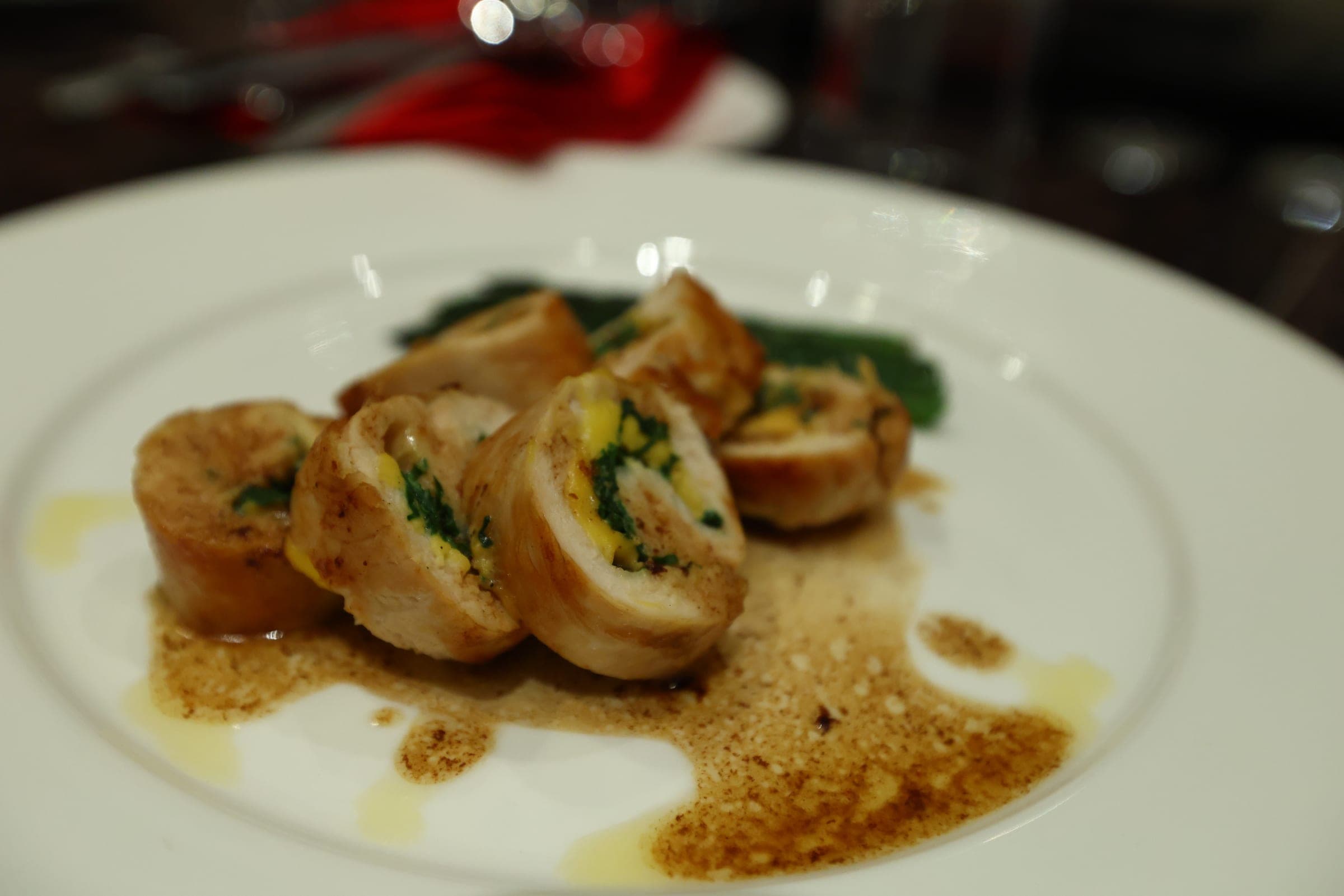 Plated fine-dining chicken roulade with seasonal vegetables