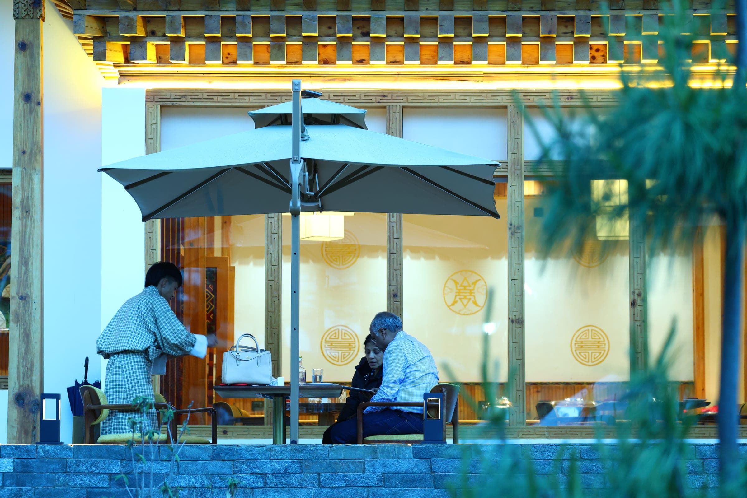 Couple dining on the terrace at dusk at Highland Glamping Paro