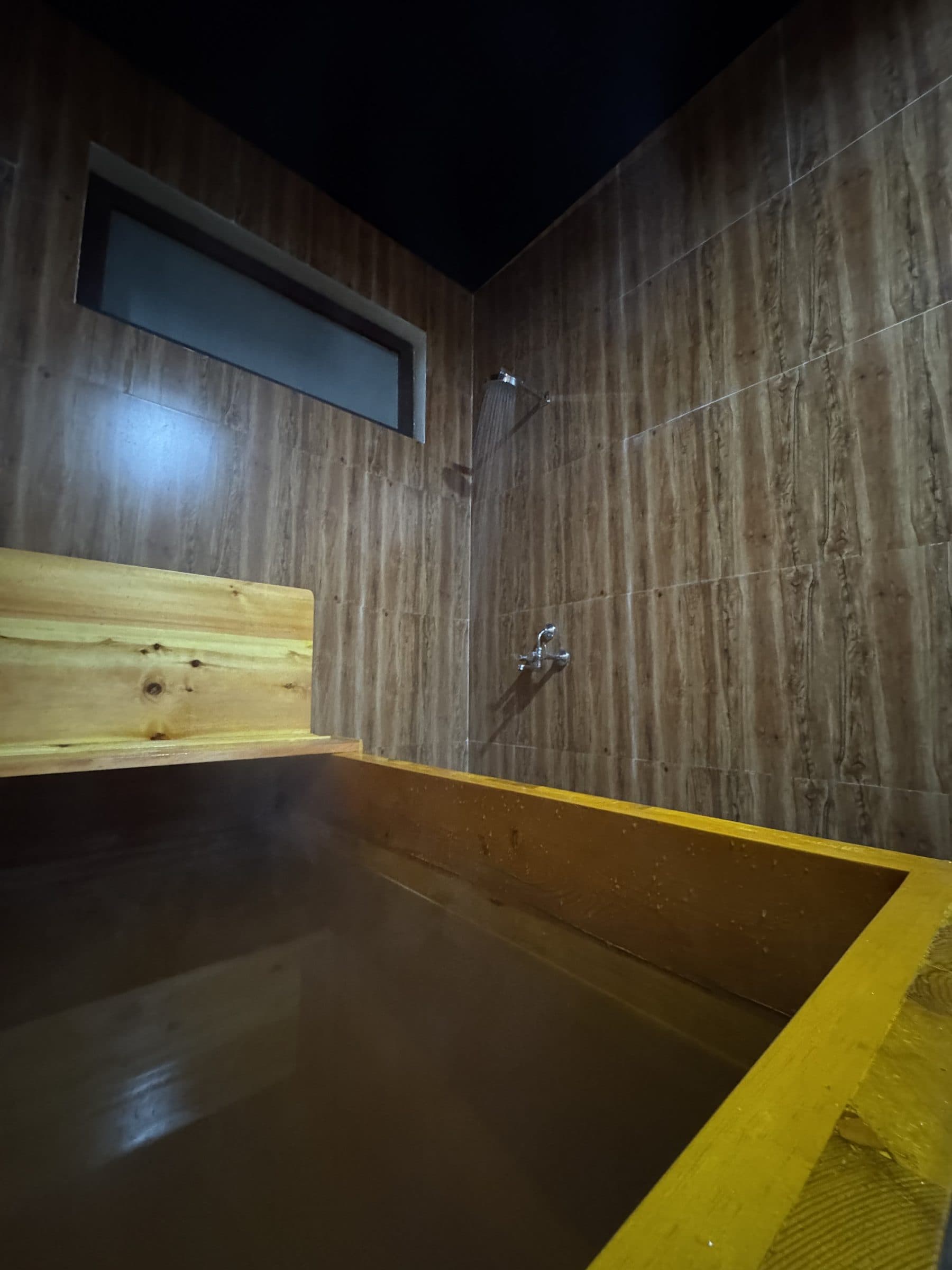 Herbal open roof hot stone bath lit at night under the sky in Paro, Bhutan