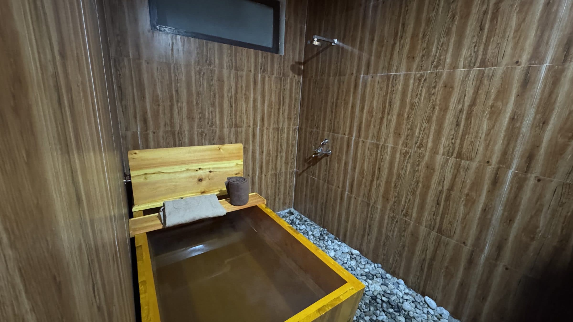 Traditional Bhutanese herbal hot stone bath in a wooden tub with heated river stones