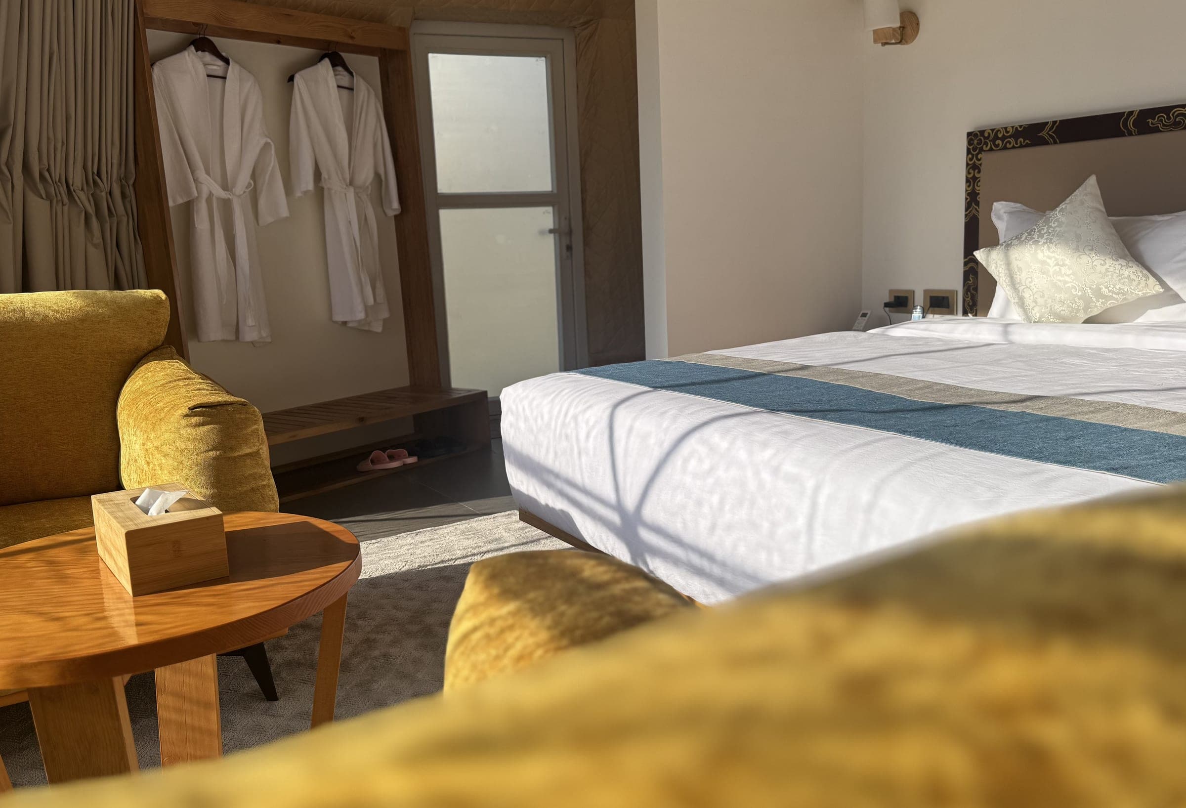 Luxury glamping dome bedroom with king bed, bathrobes and lounge armchairs at Highland Glamping Paro