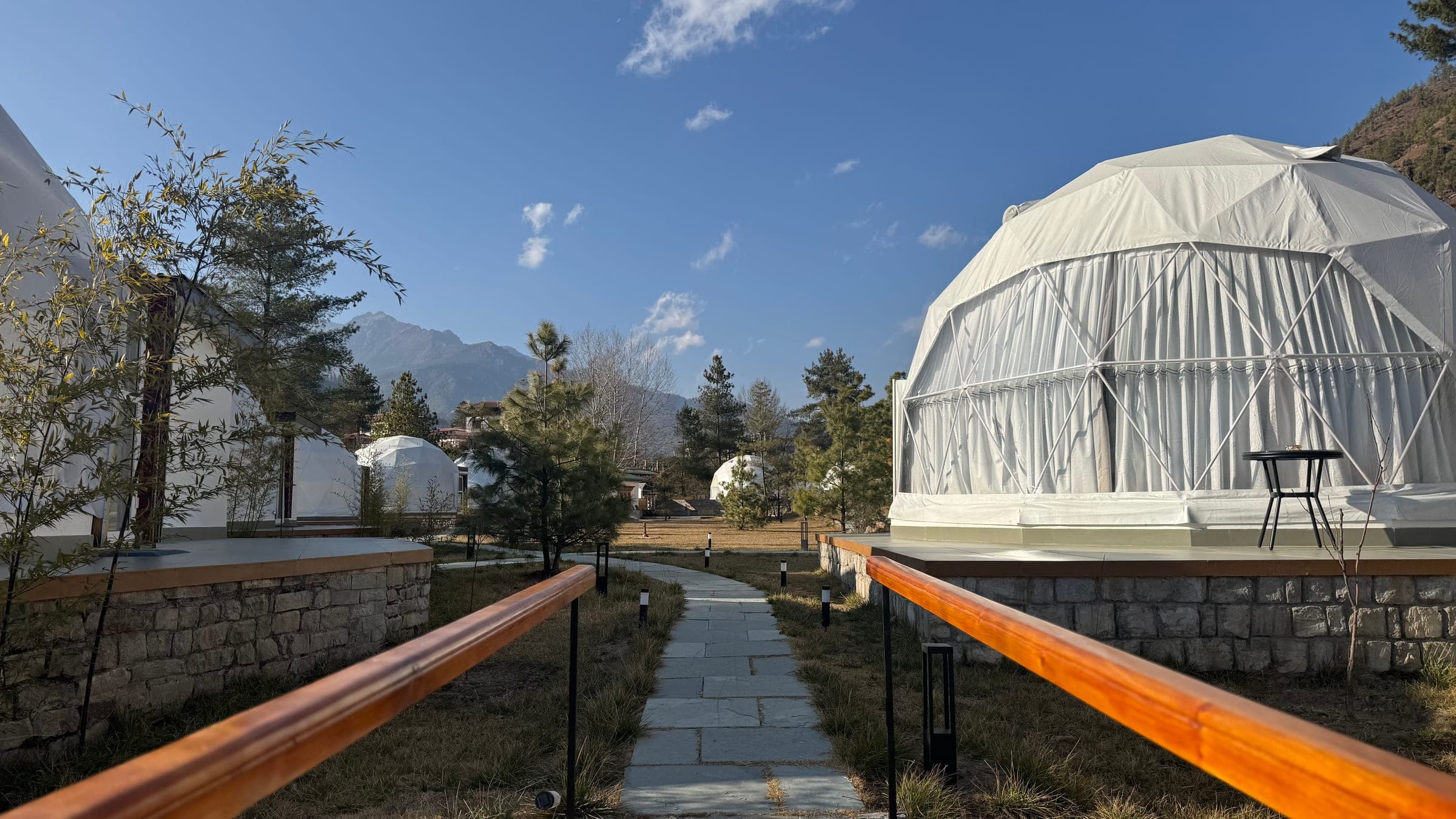 Pathway between luxury glamping domes with mountain views at Highland Glamping Paro, Bhutan