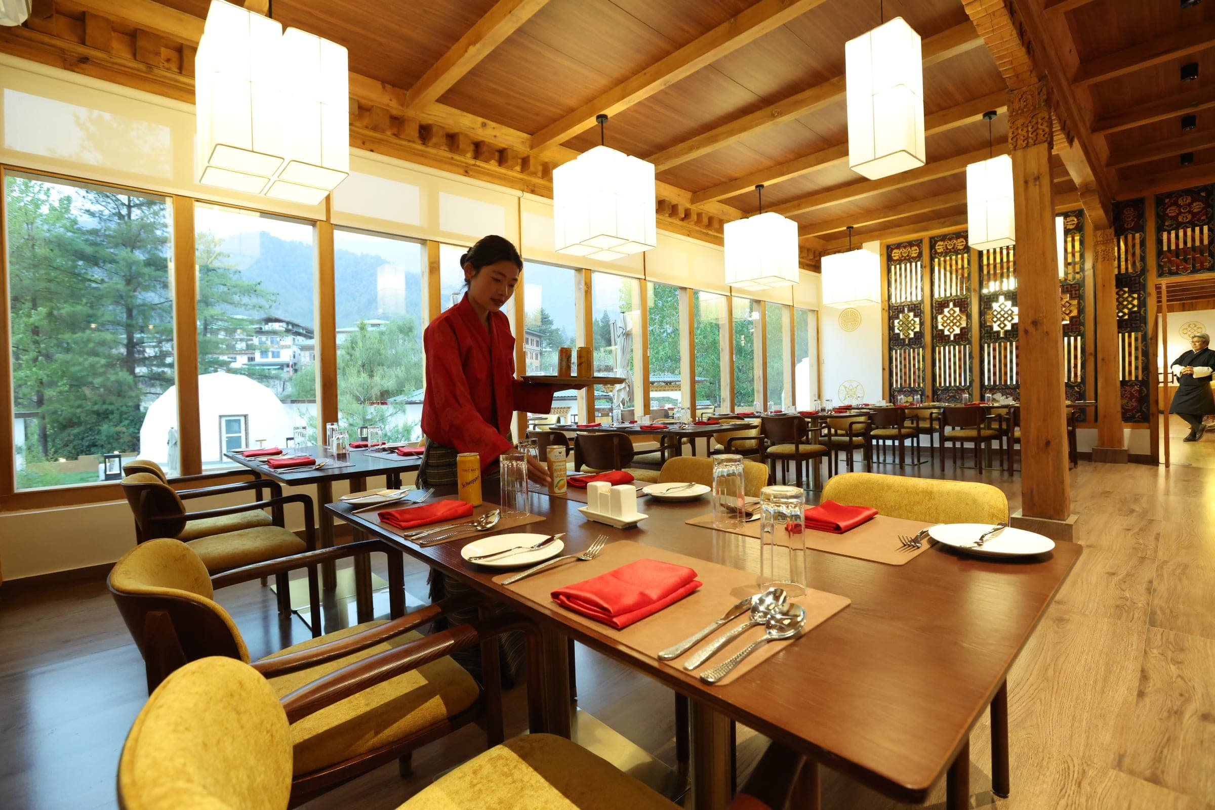 Restaurant interior with pendant lanterns and table service at Highland Glamping